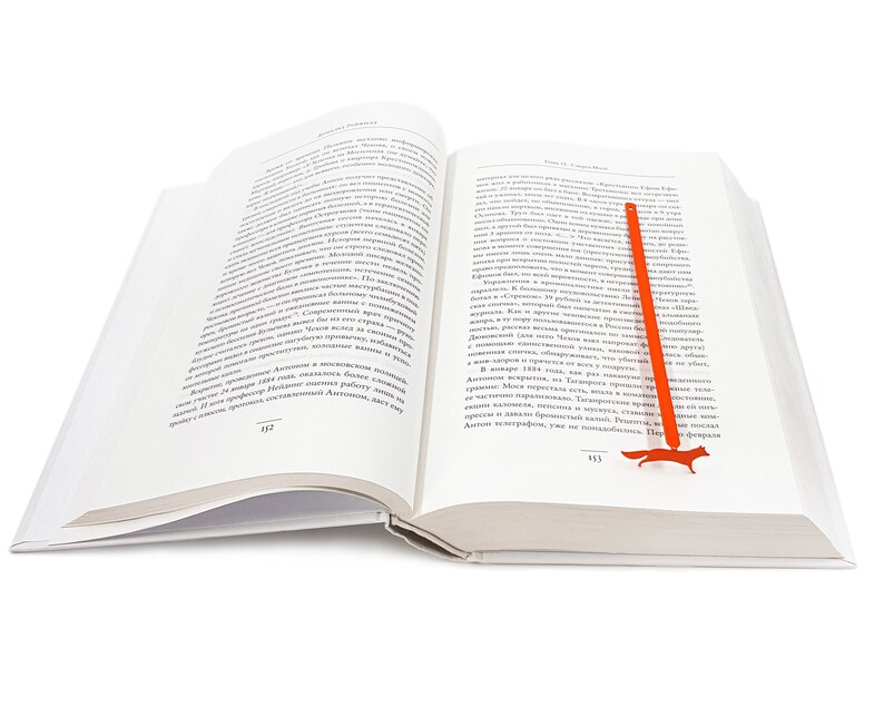 May include: An open book with a red fox bookmark. The book is open to page 333 on the left and 333 on the right. The bookmark is shaped like a fox and is made of metal.