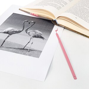 Pink metal bookmark Flamingo. A long, flat metal stick stays between the pages of the book - Cool Bookmark