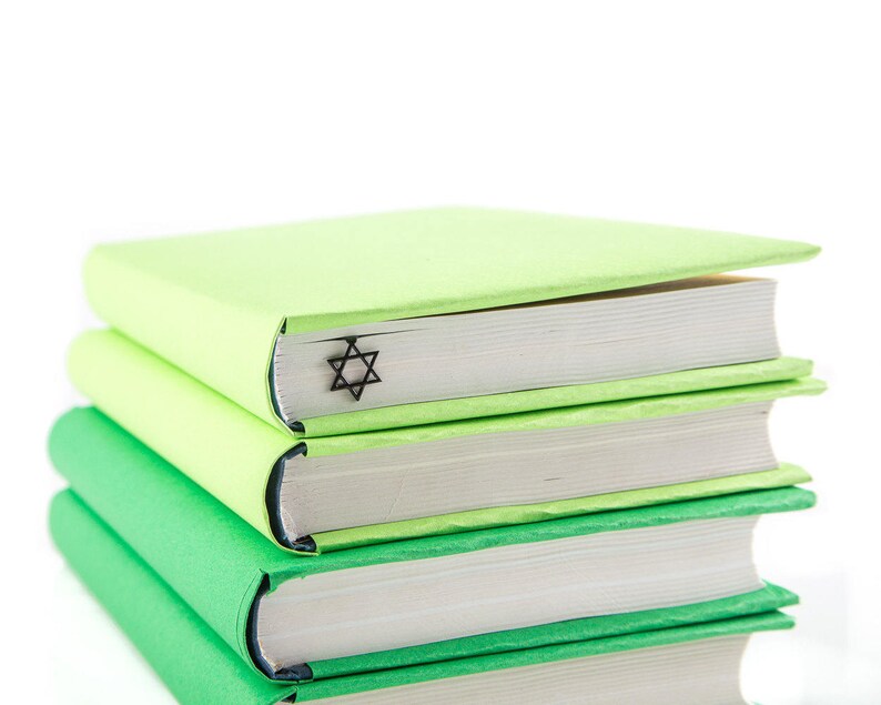 Black metal bookmark David Star. A long flat metal book stays between the pages of the book; the David star is on the side of the book. It stays visible even when the book is closed. Made in Ukraine. Not mass manufactured.