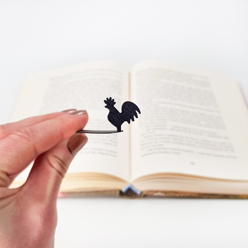 A long flat metal stick stays between the pages of the book. A silhouette of the rooster is on the side of the book, it is visible even when the book is closed. Designed and made by us in our workshop in Cherkasy, Ukraine. Not mass produced.