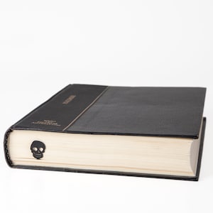 Black metal bookmark. A flat metal stic is between the pages of the book. The black skull is on the side of the book. It is seen even when the book is closed. Made by us in Cherkasy, Ukraine. Not mass manufactured.