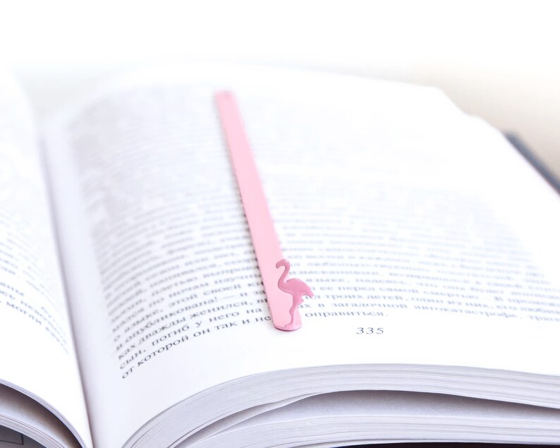 Pink metal bookmark Flamingo. A long, flat metal stick stays between the pages of the book - Cool Bookmark