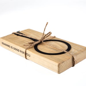 Black metal bookmark Magnifying Glass fastened to the wooden block. The writing says Reading is Good for You.