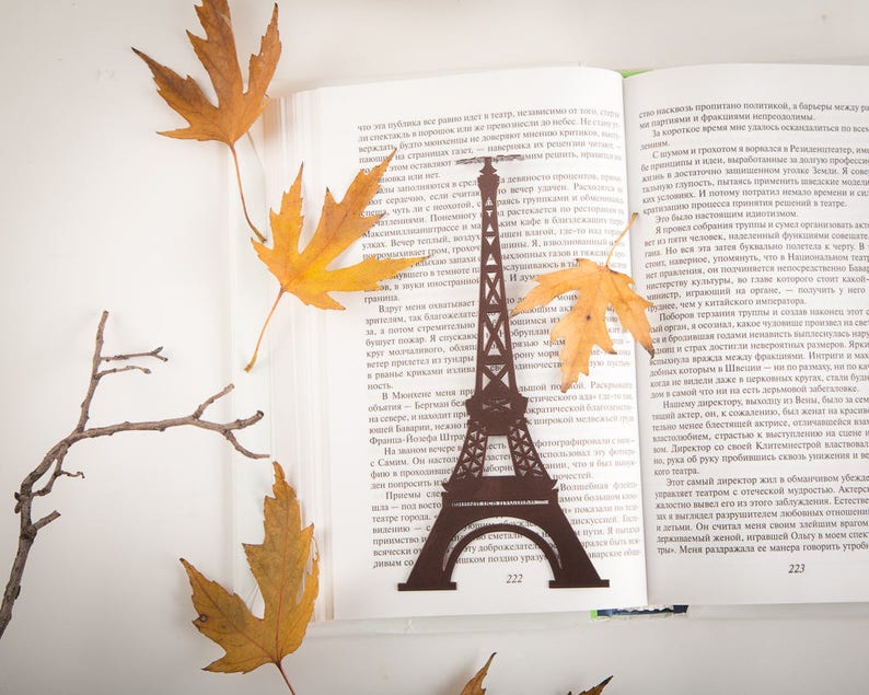 Brown metal bookmark Eifel Tower. The large tower stays between the pages of the book. The word Paris is on the side of the book.  It is visible even when the book is closed. Made in our workshop in Ukraine. Not mass manufactured.