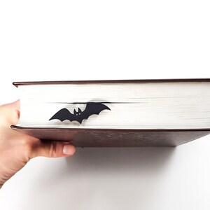 A black bat bookmark on a brown book.