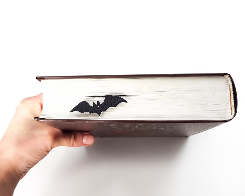 A black bat bookmark on a brown book.