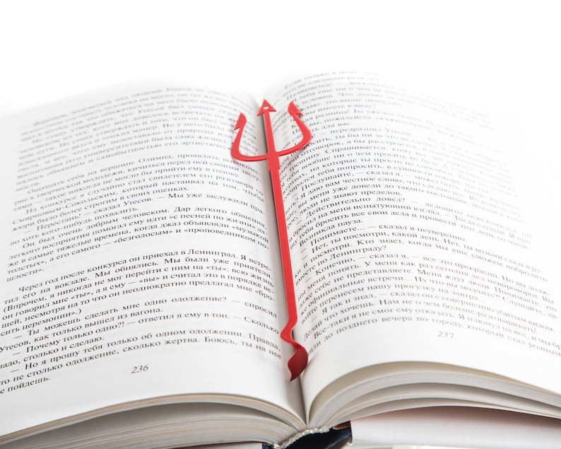 Red metal Bookmark Devil's Trident, The large trident stays between the pages of the book. The small devil's tail is on the side of the book. It is visible even when the book is closed.