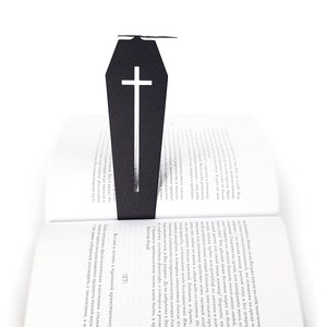 Black metal bookmark Cofiing and the bat. The large metal coffin with the cross on it stays between the pages of the book. The bat is on the side of the book. It is visible even when the book is closed. Made in Cherkasy, Ukraine. Not mass-produced.