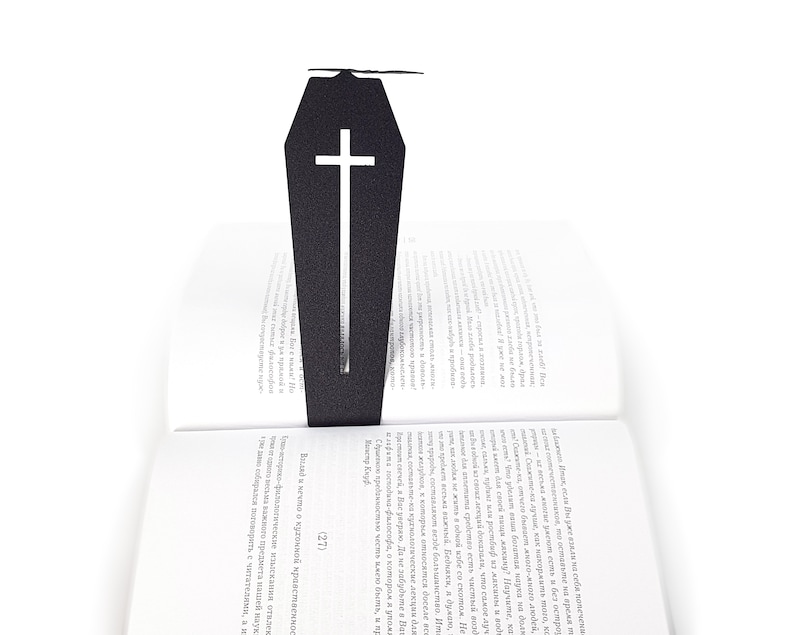 Black metal bookmark Cofiing and the bat. The large metal coffin with the cross on it stays between the pages of the book. The bat is on the side of the book. It is visible even when the book is closed. Made in Cherkasy, Ukraine. Not mass-produced.