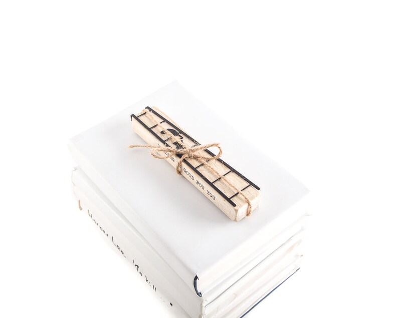 Black metal bookmark Two Cats on the Ladder fastened to the wooden black which says Reading is good for you.