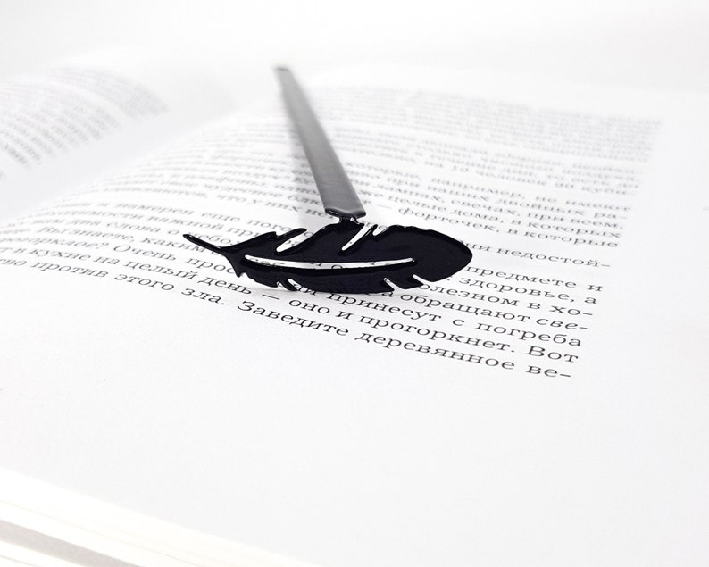 Metal bookmark Feather.  A flat metal stick stays between the pages of the book. The feather is on the side of the book. It is visible even when the book is closed. Designed and made in Ukraine. Not mass manufactured.