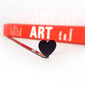 Black metal bookmark Heart. A long flat metal stick stays between the book's pages. The heart is on the side of the book. It is visible even when the book is closed. Made in Ukraine. Not mass manufactured.