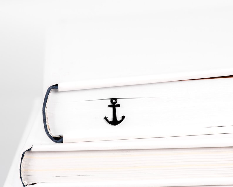 Modern minimalist style black metal bookmark Anchor. A flat metal stick sits between the pages of the book. The anchor is visible on the side of the book even when the book is closed. Made in our workshop in Ukraine. Not mass manufactured.