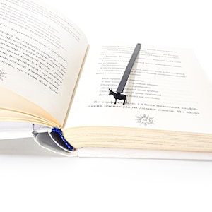 Black donkey metal bookmark clipped to open Ukrainian-language book