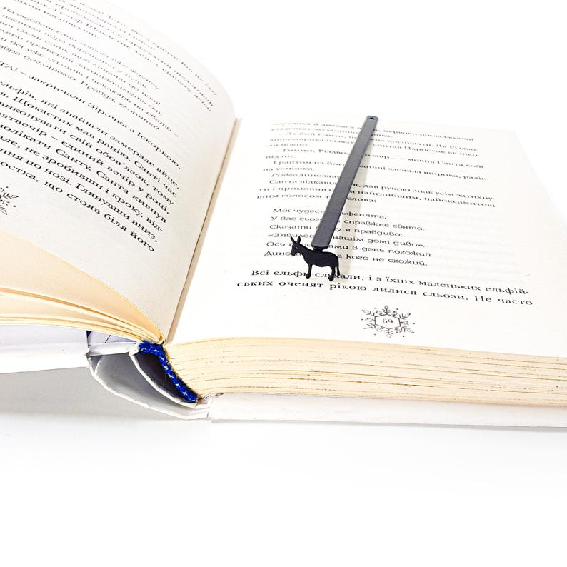 Black donkey metal bookmark clipped to open Ukrainian-language book