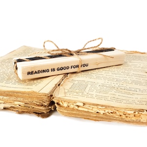 Black metal bookmark Raven on the wooden black, The block says - reading is good for you.
