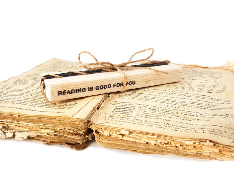 Black metal bookmark Raven on the wooden black, The block says - reading is good for you.