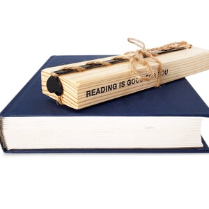 Black metal bookmark Heart on the wooden block.