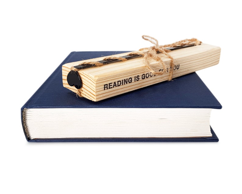 Black metal bookmark Heart on the wooden block.