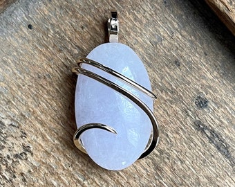 May include: A pale lavender oval-shaped stone pendant wrapped in a silver wire design.