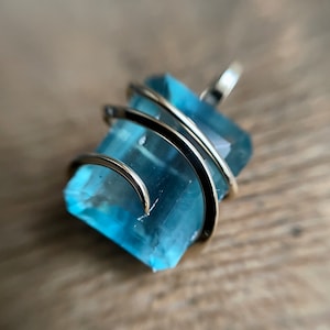 Faceted fluorite in forged 14k gold pendant
