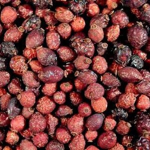 May include: A close-up image of dried rose hips. The rose hips are a deep red color and have a wrinkled texture.