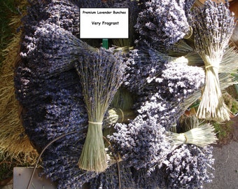 May include: A large pile of dried lavender bundles, tied with twine, in a basket. The bundles are a light purple color and have a fragrant aroma. The sign above the lavender reads "Premium Lavender Bunches Very Fragrant".