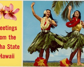 May include: Vintage postcard featuring two women in traditional Hawaiian attire, dancing under a palm tree. They wear leis, grass skirts, and floral hairpieces. The postcard has text that reads "Greetings from the Aloha State - Hawaii" with pink flowers in the upper left corner.