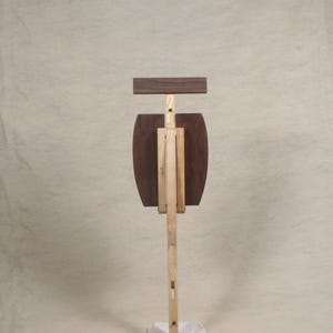May include: A wooden easel with a brown top and a white base. The easel is made of two different types of wood, one light and one dark.