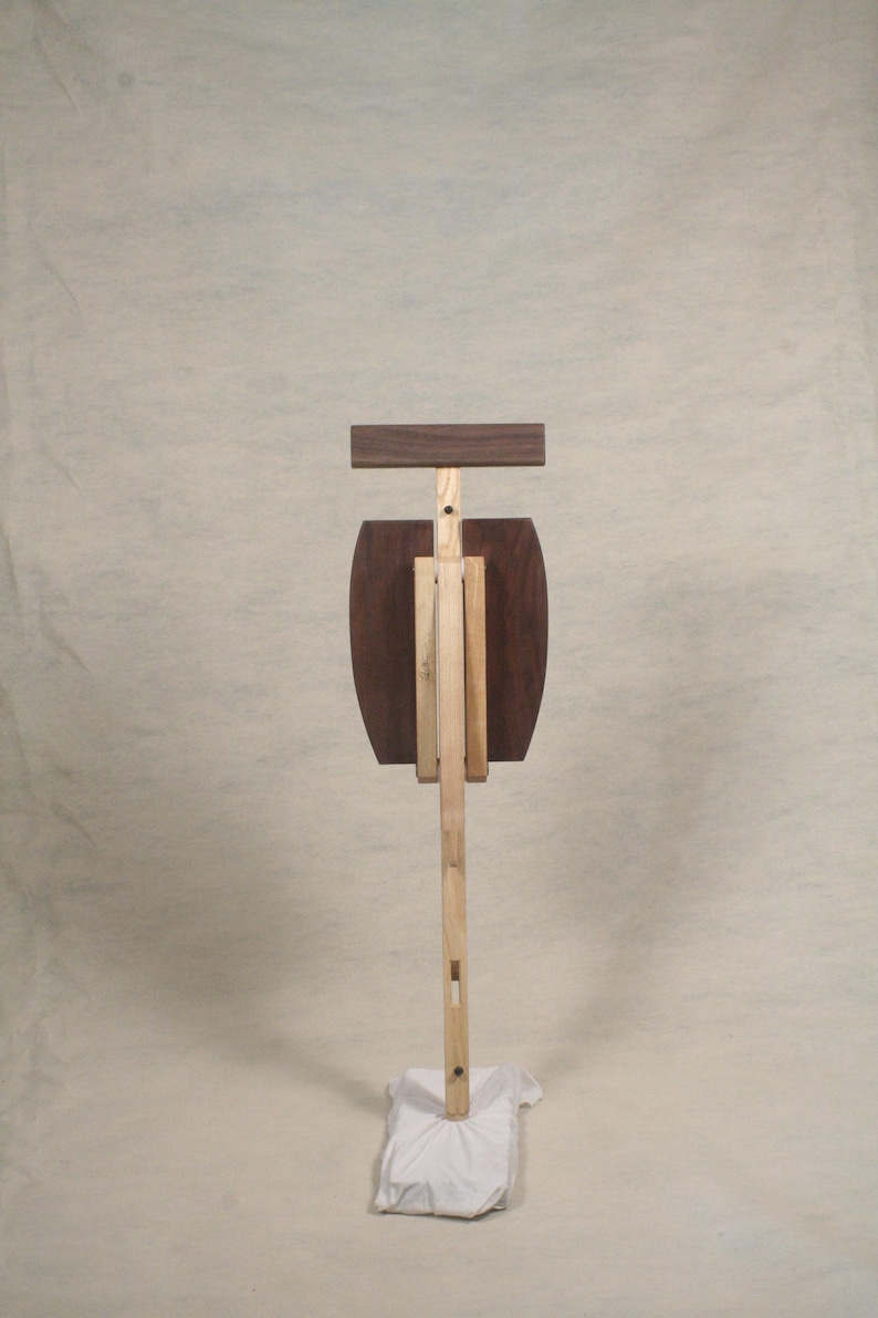 May include: A wooden easel with a brown top and a white base. The easel is made of two different types of wood, one light and one dark.