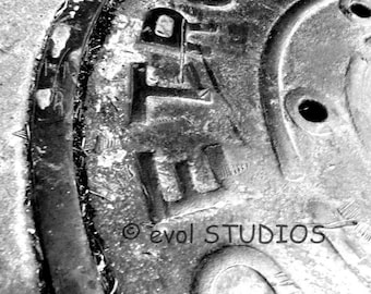 May include: Close-up of a weathered, circular metal plate with the word "BOLT" and the letters "FTA" embossed on it. The plate has a textured surface and several small holes. The copyright symbol and "evol STUDIOS" are also visible.