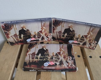 May include: Three boxes containing United States Mint Presidential $1 Coin Proof Sets. The boxes are stacked on top of each other. The top box is from 2009, the middle box is from 2008, and the bottom box is from 2007. Each box features a different set of presidents.