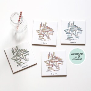 May include: Four square ceramic coasters with a colorful map design of Chelsea, MI. The coasters are available in three colors.