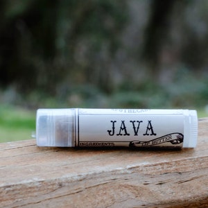 May include: A white tube of lip butter with a black label that says "JAVA" and "Lip Butter".