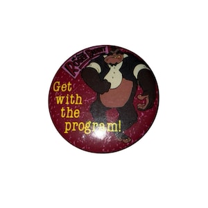 Op de afbeelding: Een ronde, kastanjebruine knoop met een cartoon gorilla in een smoking. De knoop heeft bovenaan de tekst "Roger Rabbit" en in het geel "Get with the program!". De gorilla is bruin met een wit overhemd en een zwarte smoking.