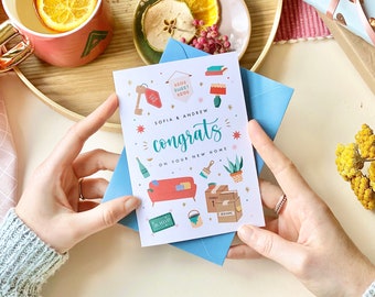 May include: A white card with a colorful illustration of home decor items and the text "Sofia & Andrew congrats on your new home".
