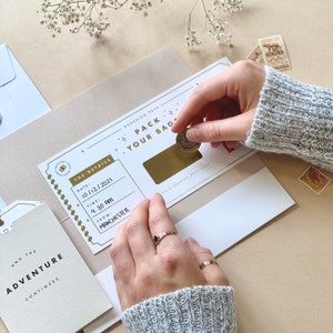 Lux Travel Scratch Card Announcement Boarding pass, with gold foil. Here we see the handwritten boarding pass scratched to see the destination. With a meal telegram and little extra card. Designed by Rodo Creative