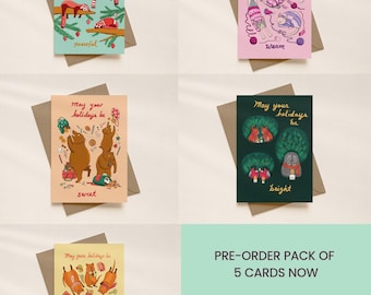 Puede incluir: Un conjunto de cinco tarjetas de felicitación ilustradas con animales y temas festivos. Las tarjetas incluyen pandas rojos, gatos con lana, osos, búhos y quokkas, cada una con el texto May your holidays be peaceful, warm, sweet, bright, or joyful.