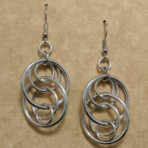 May include: Silver earrings with a design of interlocking circles.