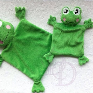 May include: Two plush green frog-shaped baby blankets. One is a square with a frog face and feet. The other is a hand puppet with a frog face, arms, and feet. Both have white eyes, black pupils, and pink cheeks.