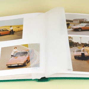 Può includere: Un album fotografico pieno di immagini di un'auto marrone. L'album ha una copertina verde ed è aperto a una pagina con quattro foto. Le foto mostrano l'auto in diverse ambientazioni, tra cui un campo, un parcheggio e una strada.