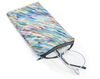 Op de afbeelding: Een brilletje met rits met een kleurrijk abstract patroon in tinten blauw, groen, bruin en roze. De etui is open en een bril zit gedeeltelijk erin.