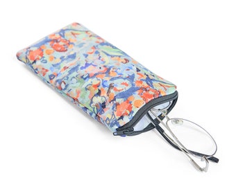 Op de afbeelding: Een brilletje met een bloemenpatroon en een ritssluiting. Het etui is open en een paar leesbrillen bevinden zich gedeeltelijk erin.