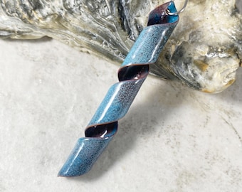 May include: A blue and purple enamel spiral pendant necklace. The pendant is made of metal and has a textured surface.