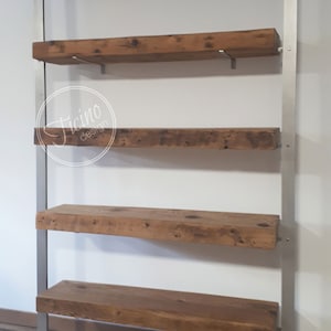 May include: A rustic wooden shelf unit with five shelves supported by a silver metal frame. The shelves are made of reclaimed wood with a natural finish. The metal frame has a simple design with straight lines and a base that is slightly wider than the top.