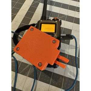 May include: A handheld two-way radio with an orange protective cover and a blue lanyard. The radio's screen displays numbers. The cover is secured with four screws. The antenna is black.