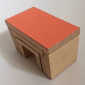 May include: A wooden toy house with a bright orange roof. The house has three levels with a small opening on the bottom level.