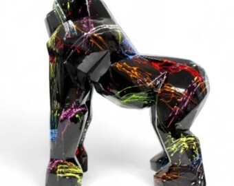 May include: A black gorilla sculpture with a glossy finish. The gorilla is decorated with colorful paint splatters in shades of red, yellow, green, and purple. The sculpture is in a crouching position.