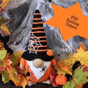 May include: A knitted Halloween gnome wearing a black and orange striped hat with a spiderweb design. The gnome is holding a small orange pumpkin and is surrounded by autumn leaves and spiderwebs. PDF Knitting Pattern.