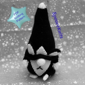Peut inclure: Un gnome tricoté noir et blanc, avec un long chapeau pointu et une barbe blanche. Le gnome a un corps noir et des détails blancs. Le texte "PDF Knitting Pattern" est dans une étoile bleue. Le texte "SpoooeKnits" est en bleu.